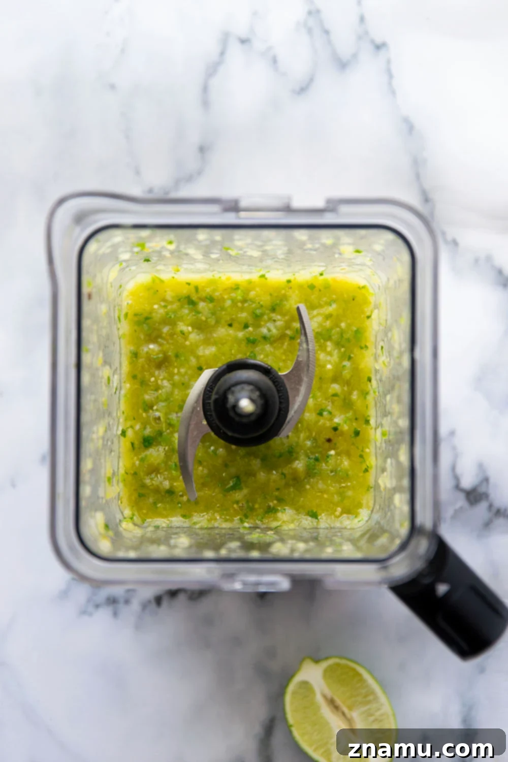 Close-up of Instant Pot Barbacoa Beef Tacos topped with fresh pineapple tomatillo salsa, cilantro, and onion.