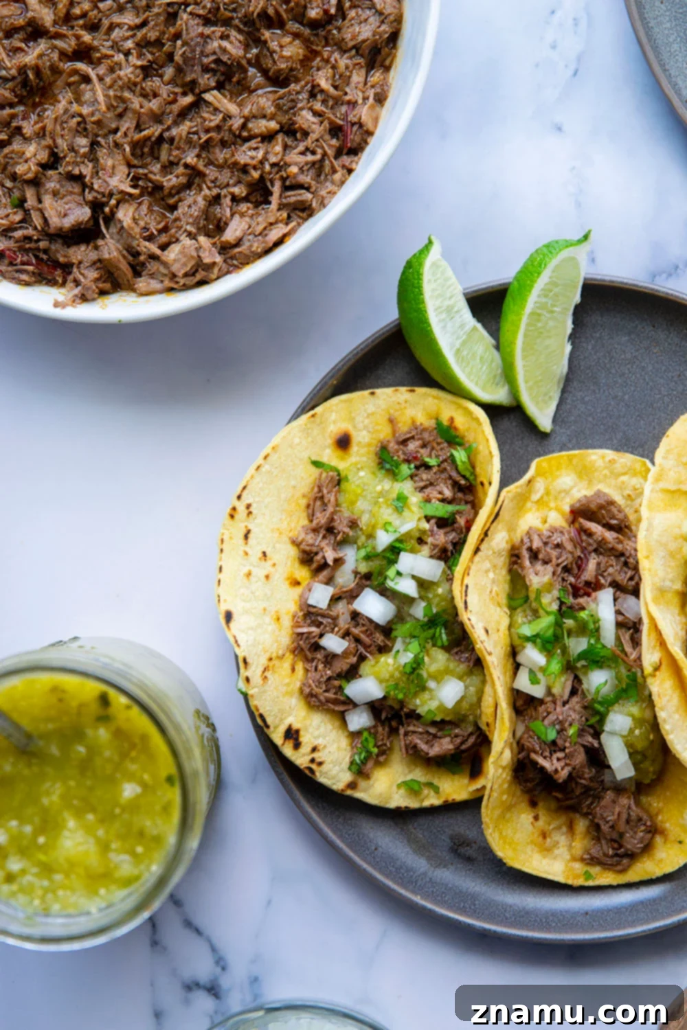 A vibrant platter of Instant Pot Barbacoa Beef Tacos with roasted pineapple tomatillo salsa.