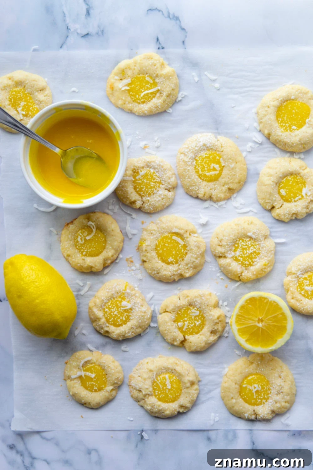 Coconut Lemon Curd Thumbprints 2 Close-up of a perfectly baked lemon curd thumbprint cookie, showcasing the golden shortbread and vibrant yellow lemon curd center.