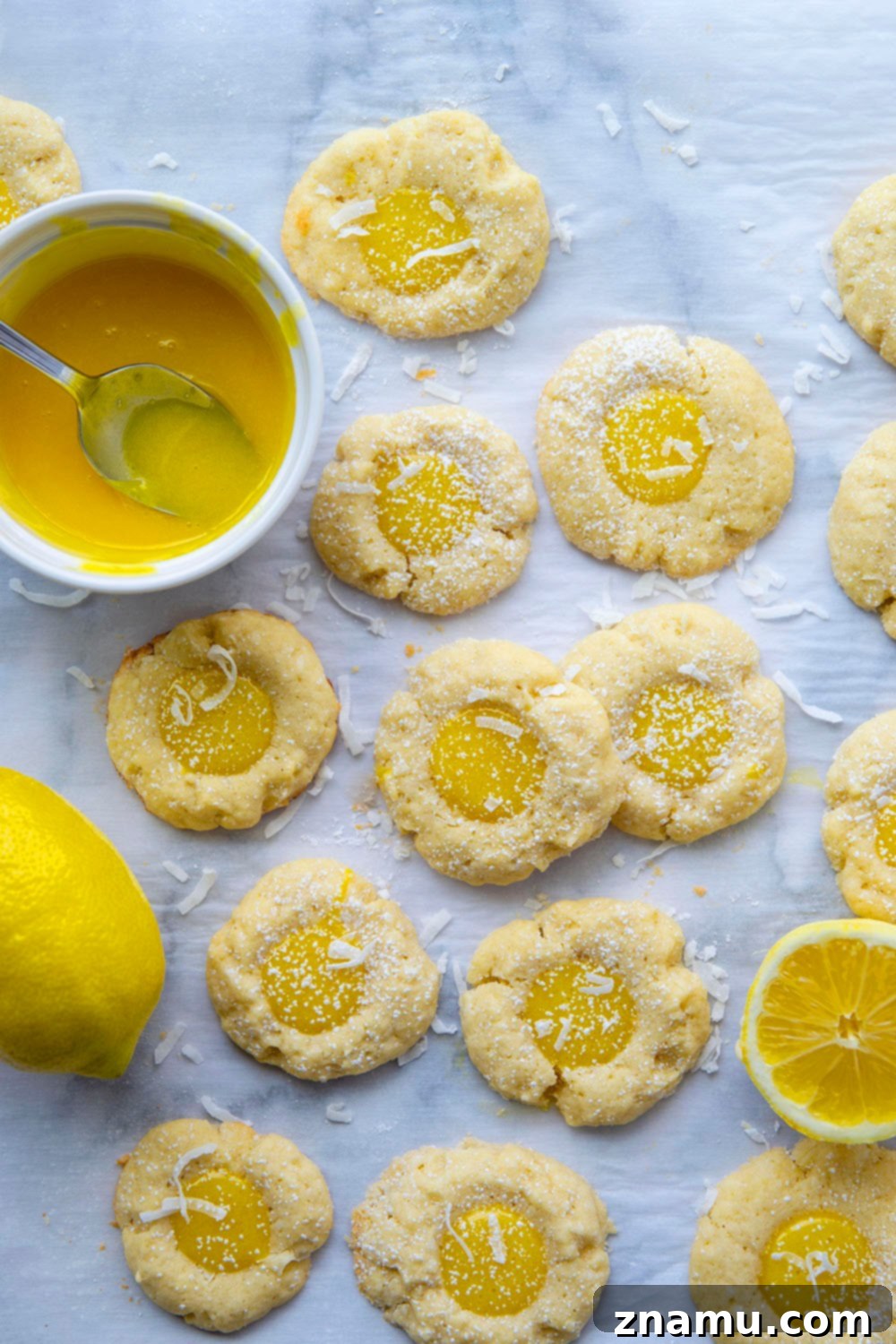 Coconut Lemon Curd Thumbprints 5 A tray of unbaked shortbread cookie balls with thumbprint indentations, ready for chilling.