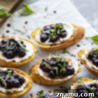 This blueberry ricotta bruschetta features crisp French bread slices with a thick layer of creamy ricotta and juicy basil roasted blueberries. - a perfect last-minute app to throw together!