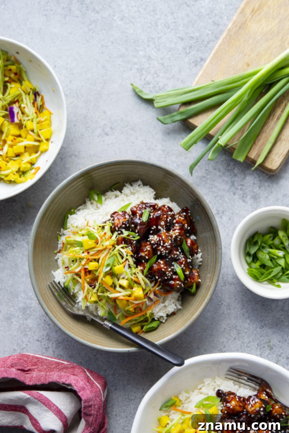 Smoky Korean BBQ Tofu Bowls with Spicy Mango Slaw 3 Korean BBQ tofu bowls feature perfectly crisp and saucy tofu piled over fluffy rice with a sweet and spicy mango slaw on top.