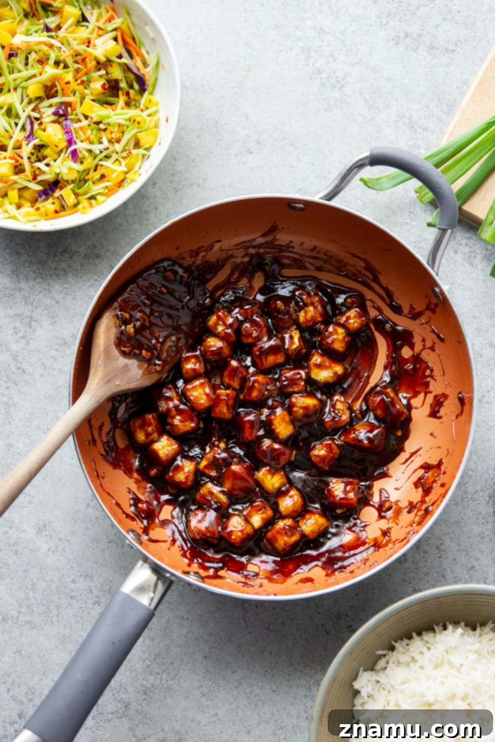 Smoky Korean BBQ Tofu Bowls with Spicy Mango Slaw 4 Korean BBQ tofu bowls feature perfectly crisp and saucy tofu piled over fluffy rice with a sweet and spicy mango slaw on top.