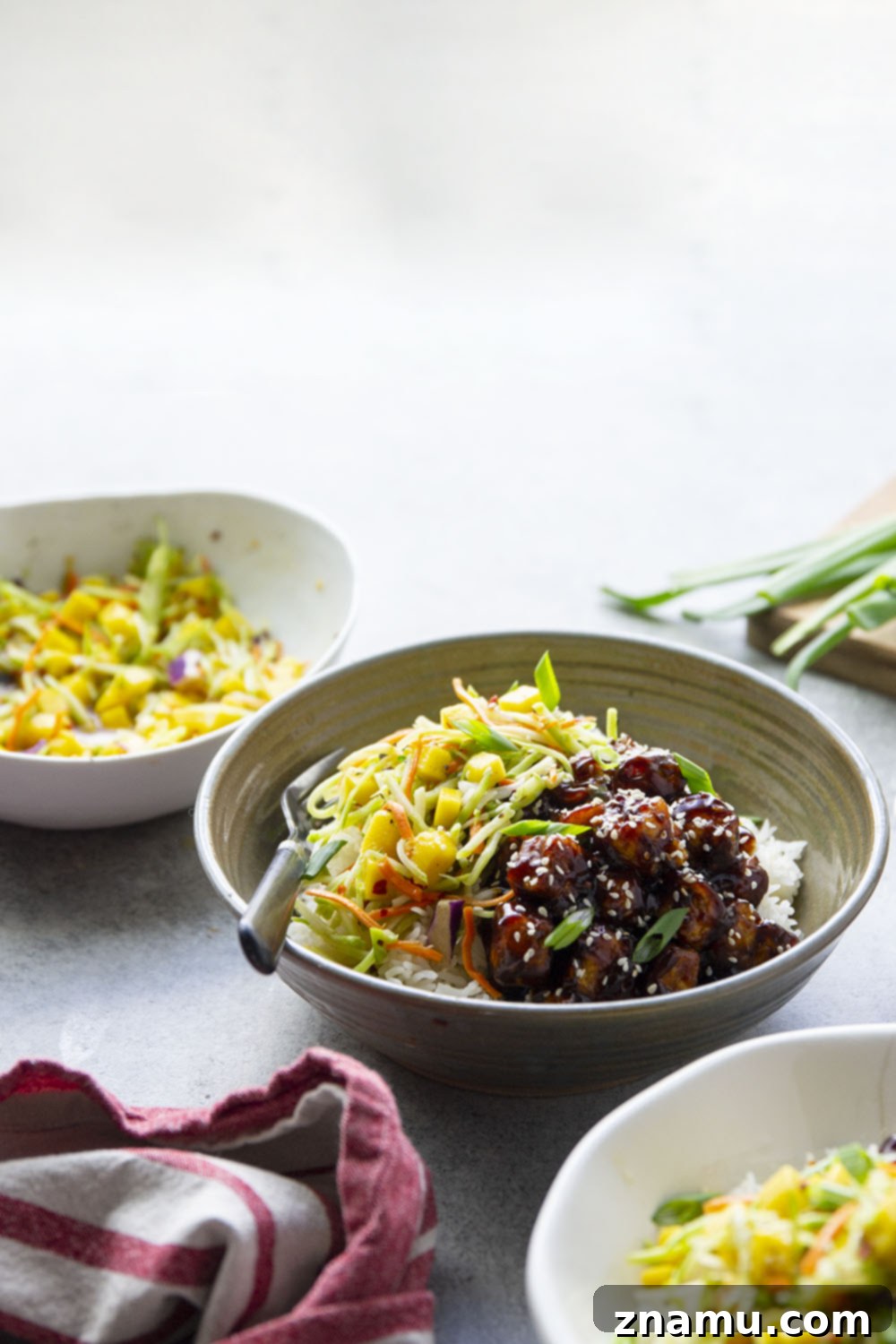 Smoky Korean BBQ Tofu Bowls with Spicy Mango Slaw 6 Korean BBQ tofu bowls feature perfectly crisp and saucy tofu piled over fluffy rice with a sweet and spicy mango slaw on top.