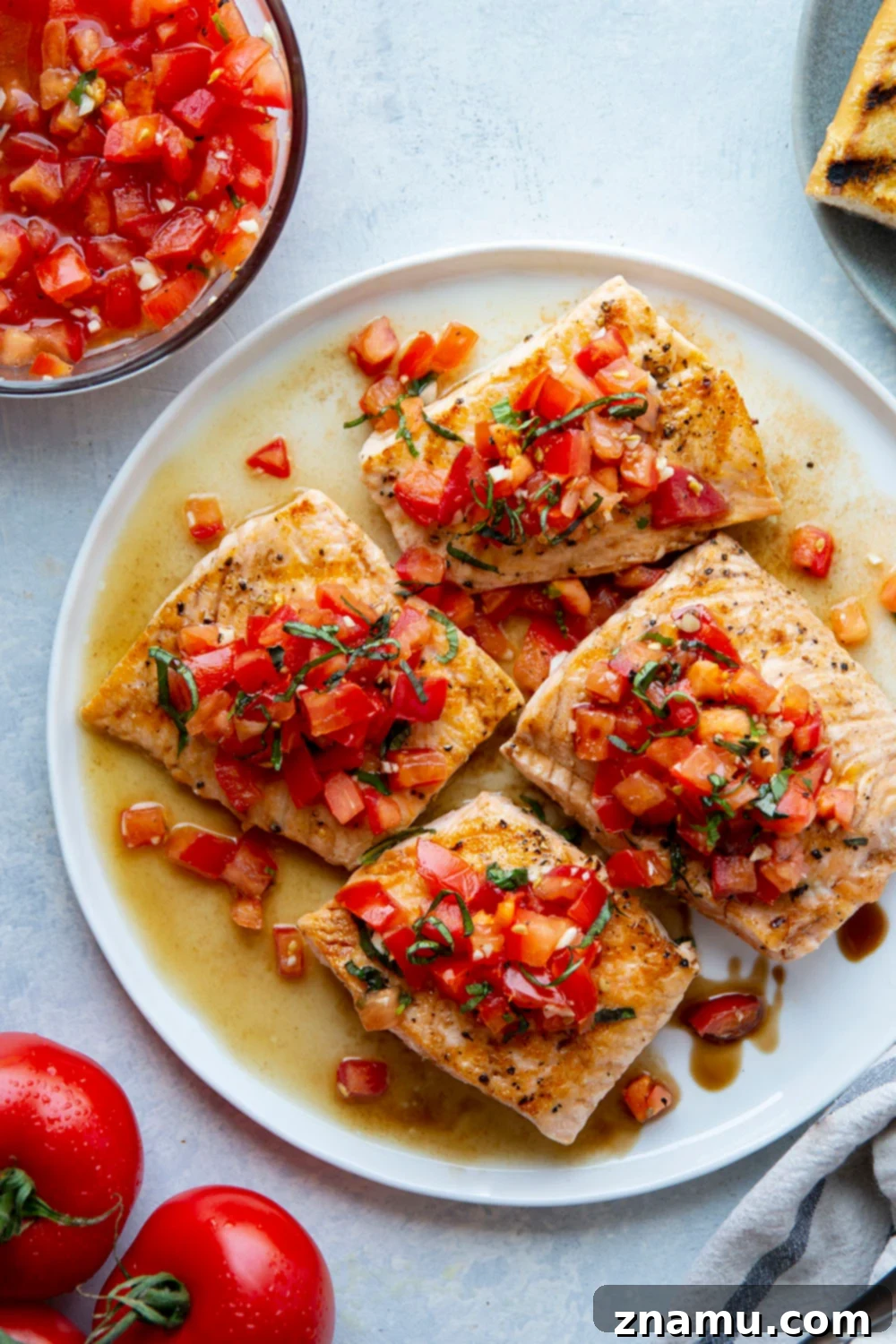 Close-up of Bruschetta Topping on Salmon This grilled bruschetta salmon features perfectly grilled salmon fillets with a flavorful tomato bruschetta topping piled over top and lots of crusty grilled bread on the side.