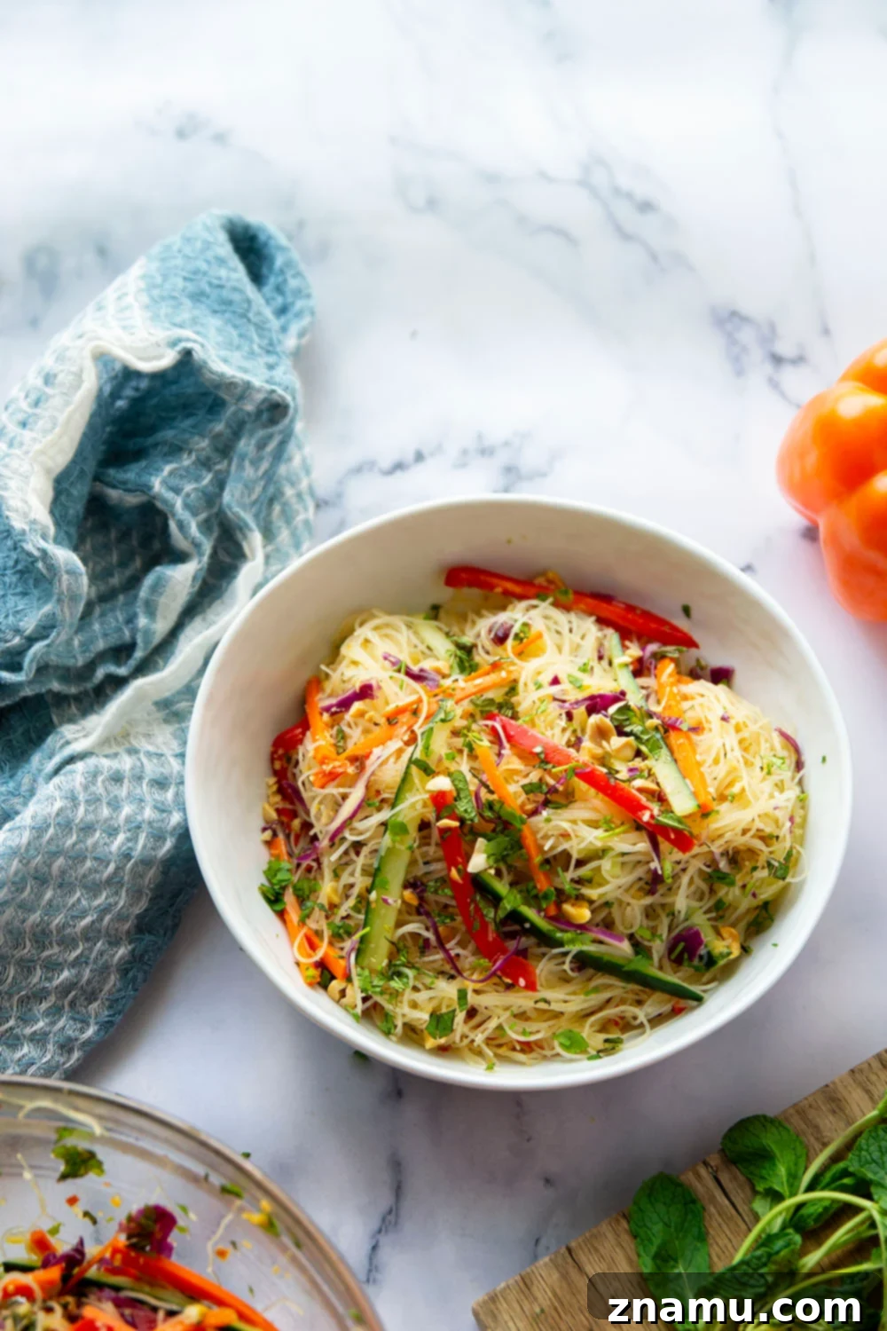 Vibrant Spring Roll Salad with Zesty Ginger Dressing 6 A beautifully plated spring roll salad, ready to be enjoyed, showing the vibrant mix of vegetables, noodles, and dressing, garnished with peanuts and herbs.