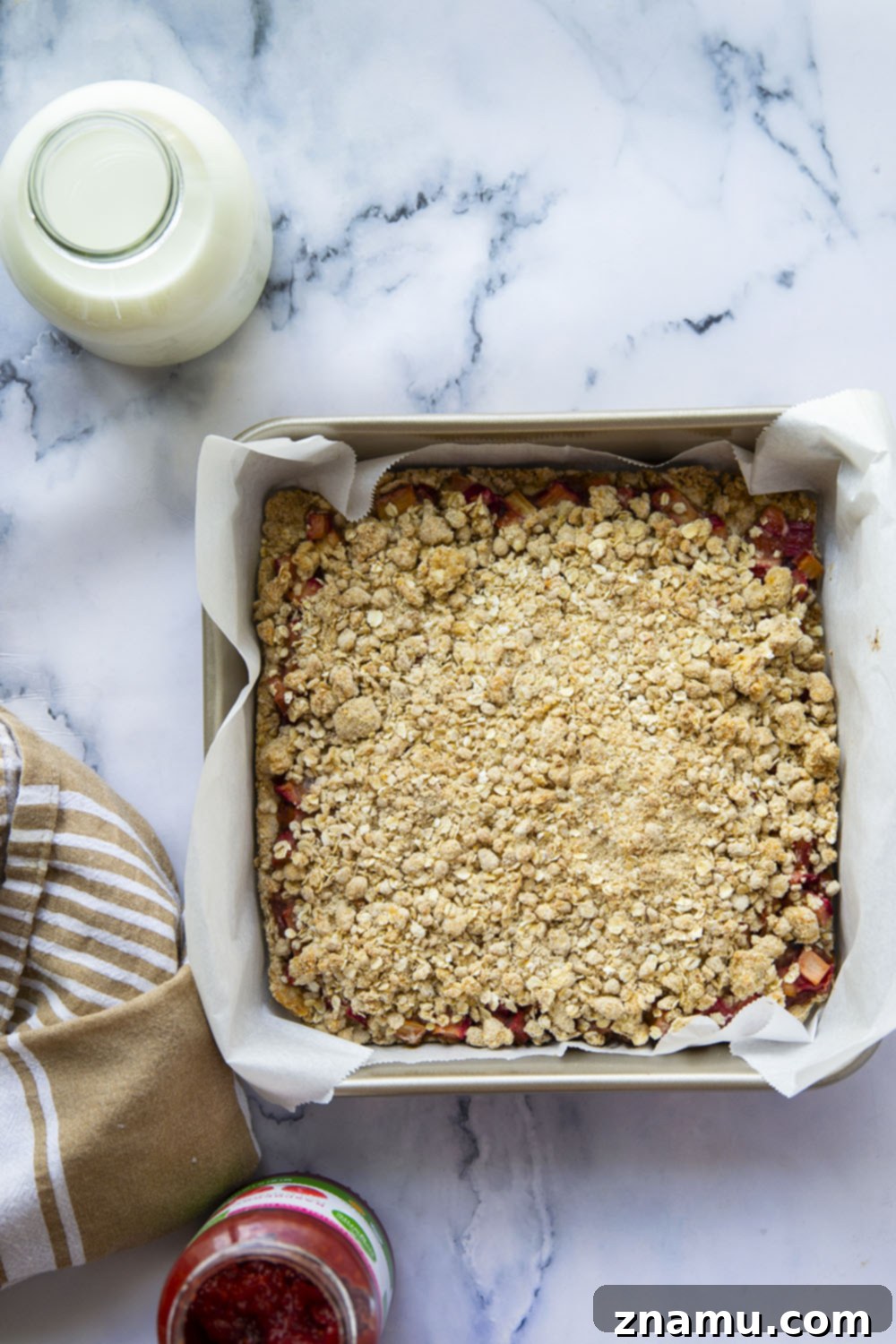 Summer Raspberry Rhubarb Crumble Bars 3 Close-up of a single raspberry rhubarb oatmeal bar, showcasing the fruit filling and the crumbly oat topping.
