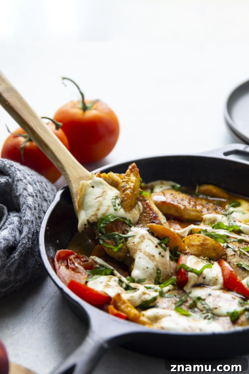 One-Pan Peach Caprese Chicken 4 Close-up of melted mozzarella and fresh basil on top of Caprese Peach Chicken.