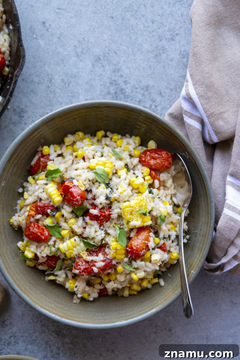 Golden Corn Risotto with Sun-Kissed Tomatoes 6 A bowl of creamy sweet corn risotto topped with fresh herbs and bursting tomatoes.