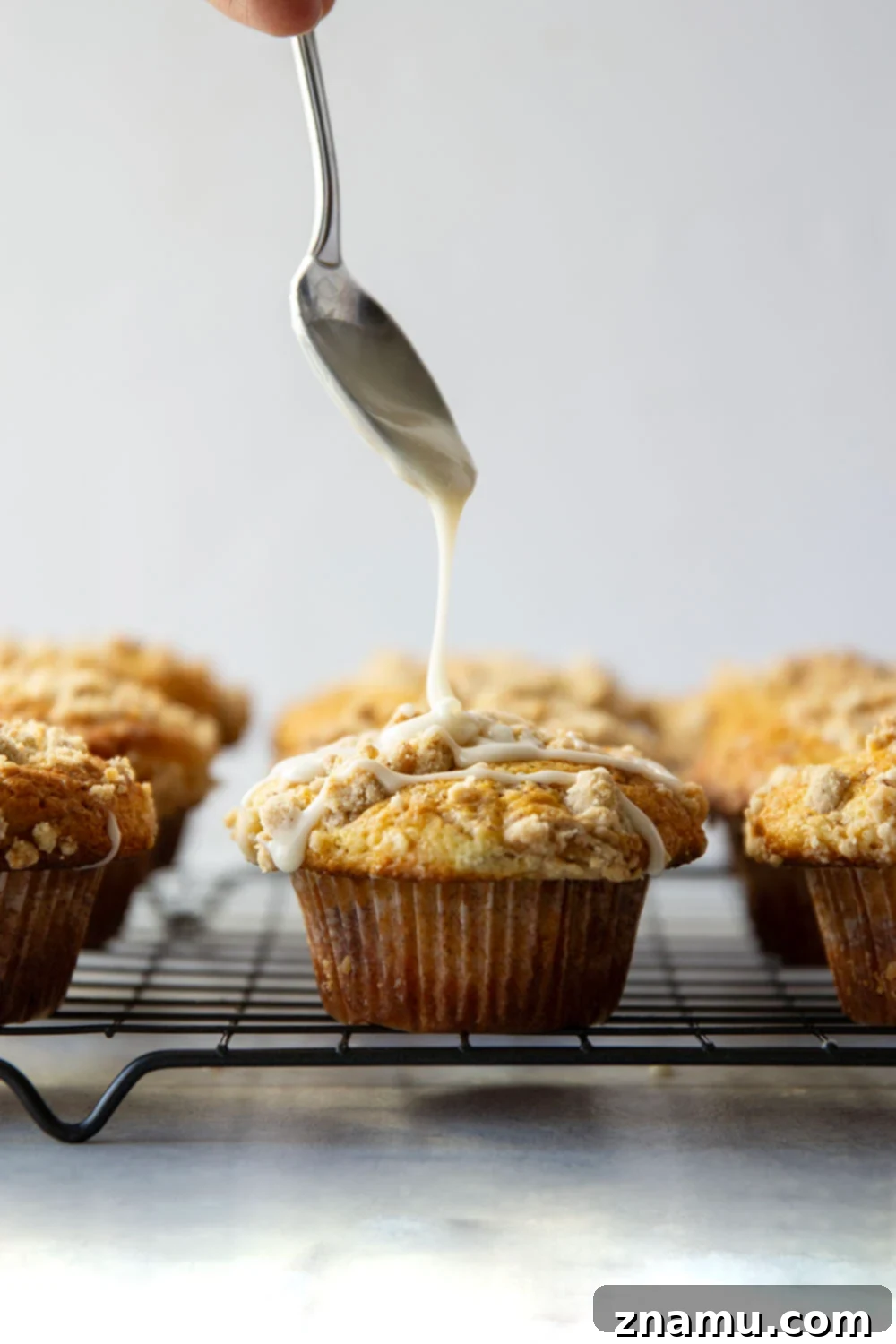 Streusel Coffee Cake Muffins 4 A trio of delicious Coffee Cake Muffins, beautifully baked and ready to be glazed, showcasing their crumbly streusel topping.