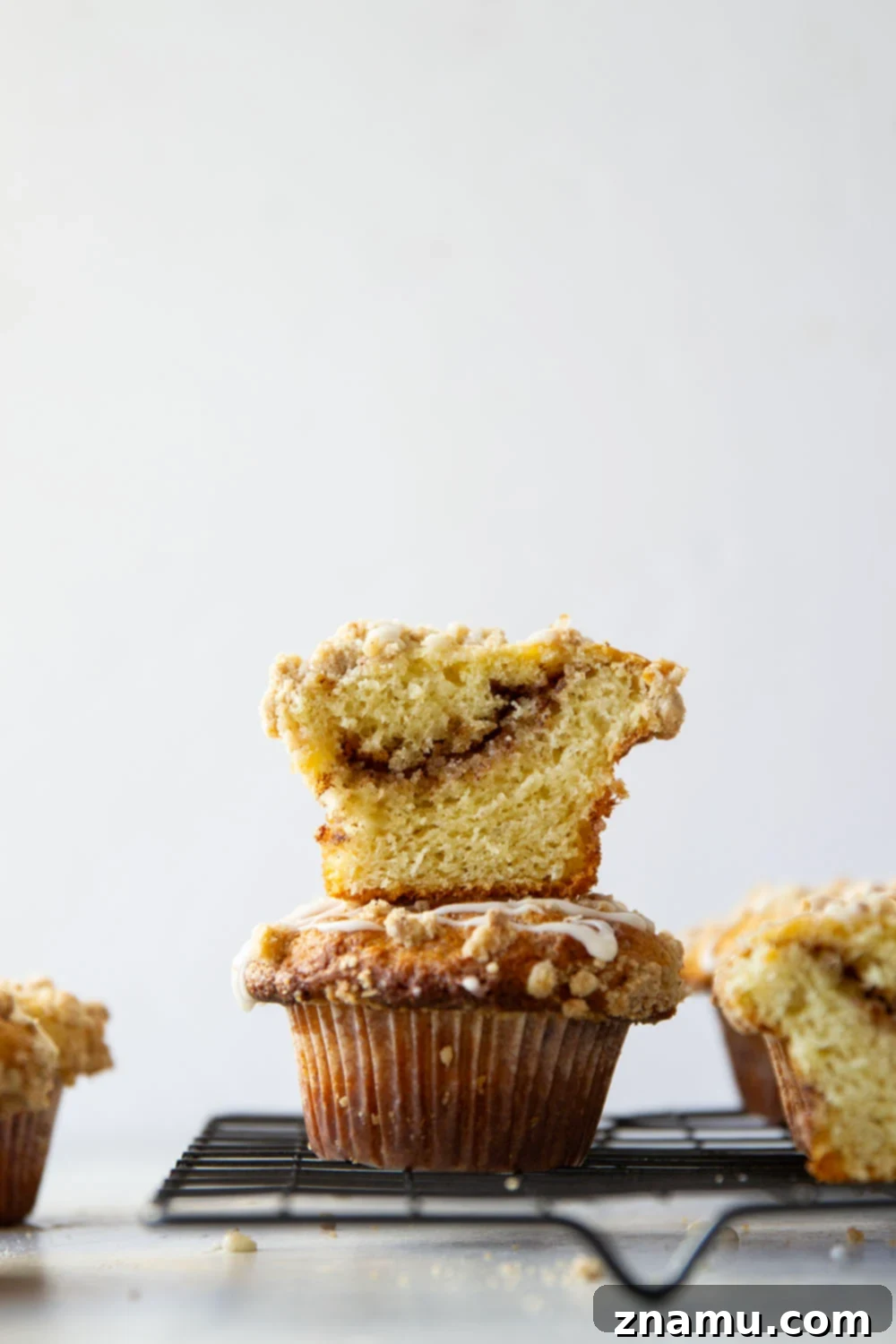 Streusel Coffee Cake Muffins 5 Freshly baked Coffee Cake Muffins cooling on a wire rack, topped with golden streusel.