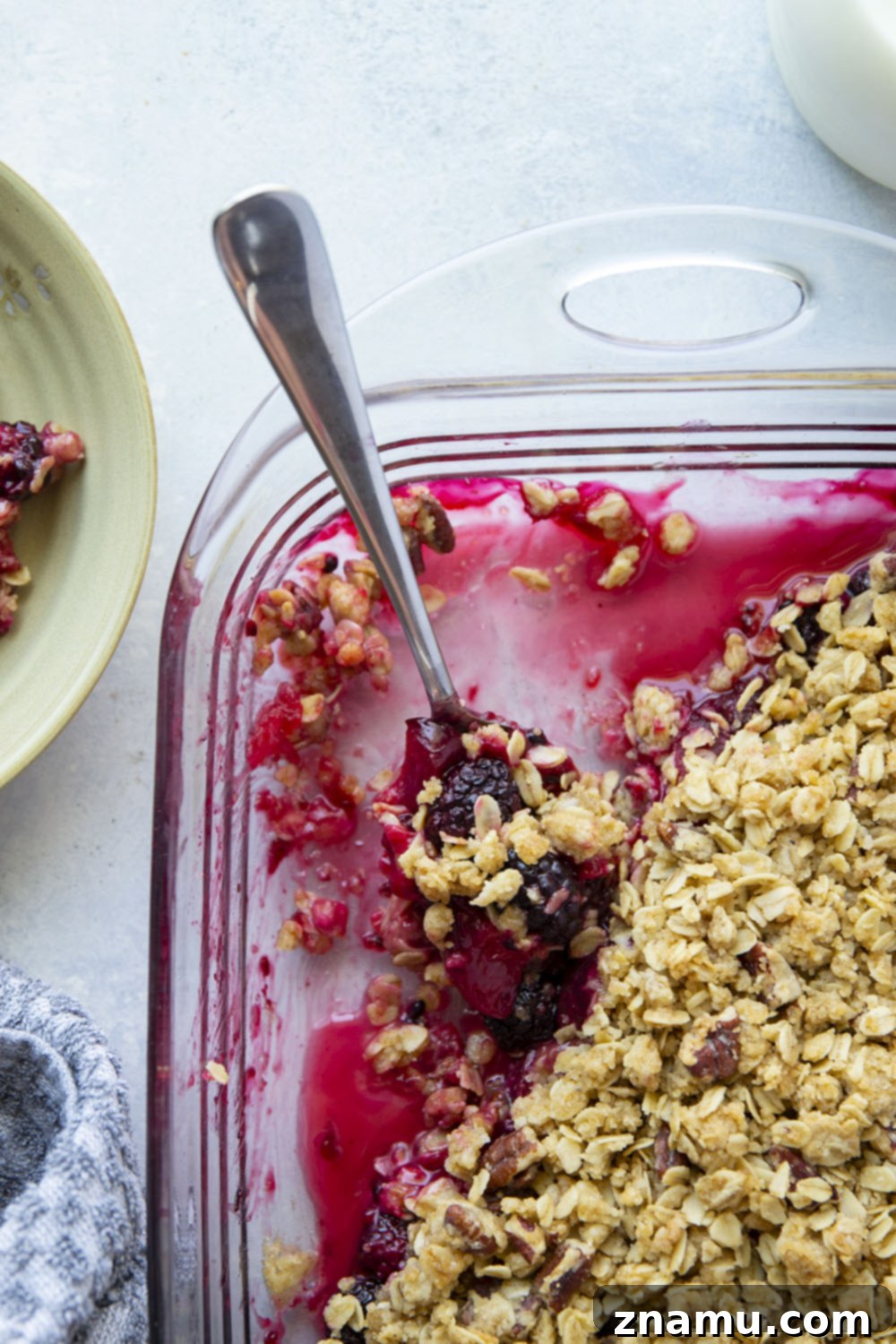 Ruby Harvest Crisp 5 A close-up of a partially baked Blackberry Plum Crisp, showing the edges of the golden-brown streusel and the bubbling fruit filling just peeking through.