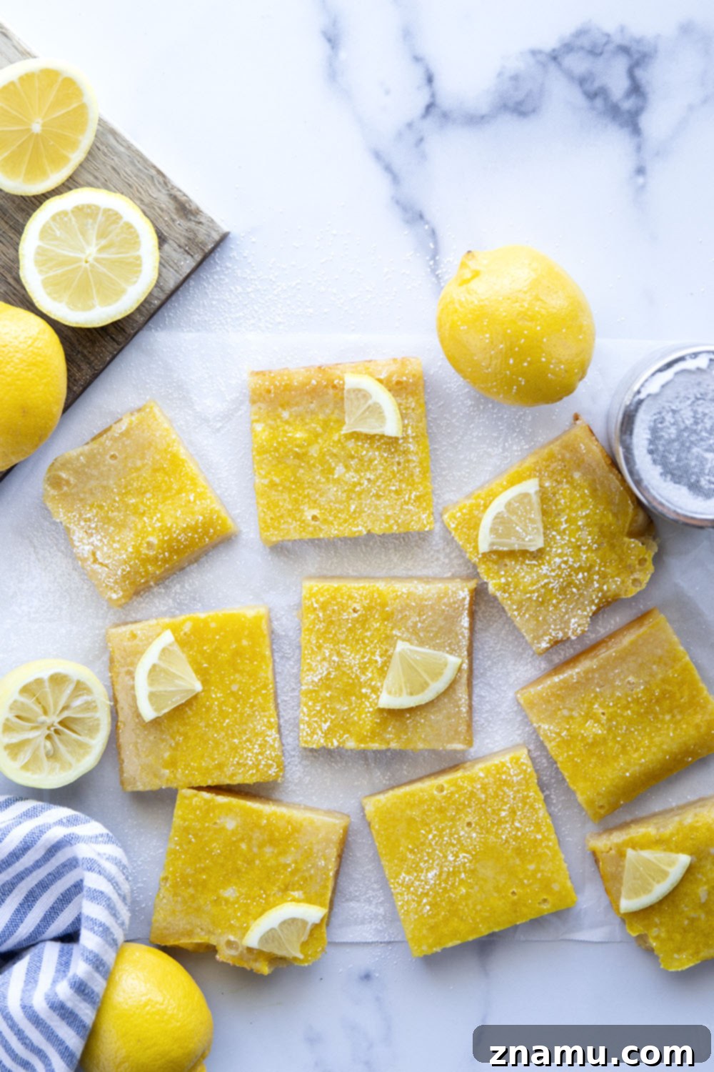 Perfect Lemon Bars 4 A stack of lemon bars, glistening with powdered sugar, showcasing the thick shortbread base and sunny yellow filling.