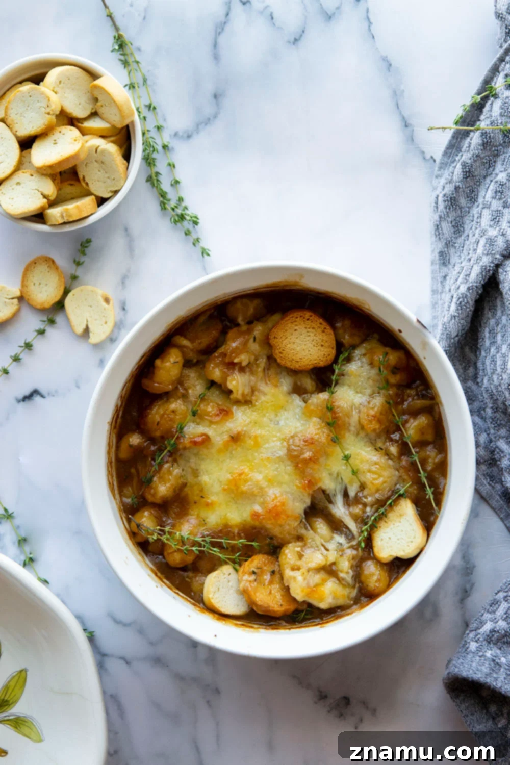 Savory Onion Gnocchi Gratin 3 This baked French onion gnocchi is like a heartier version of the classic soup! Tender gnocchi is baked in a flavorful caramelized onion beef broth with lots of rich cheese on top and French bread slices for dipping.