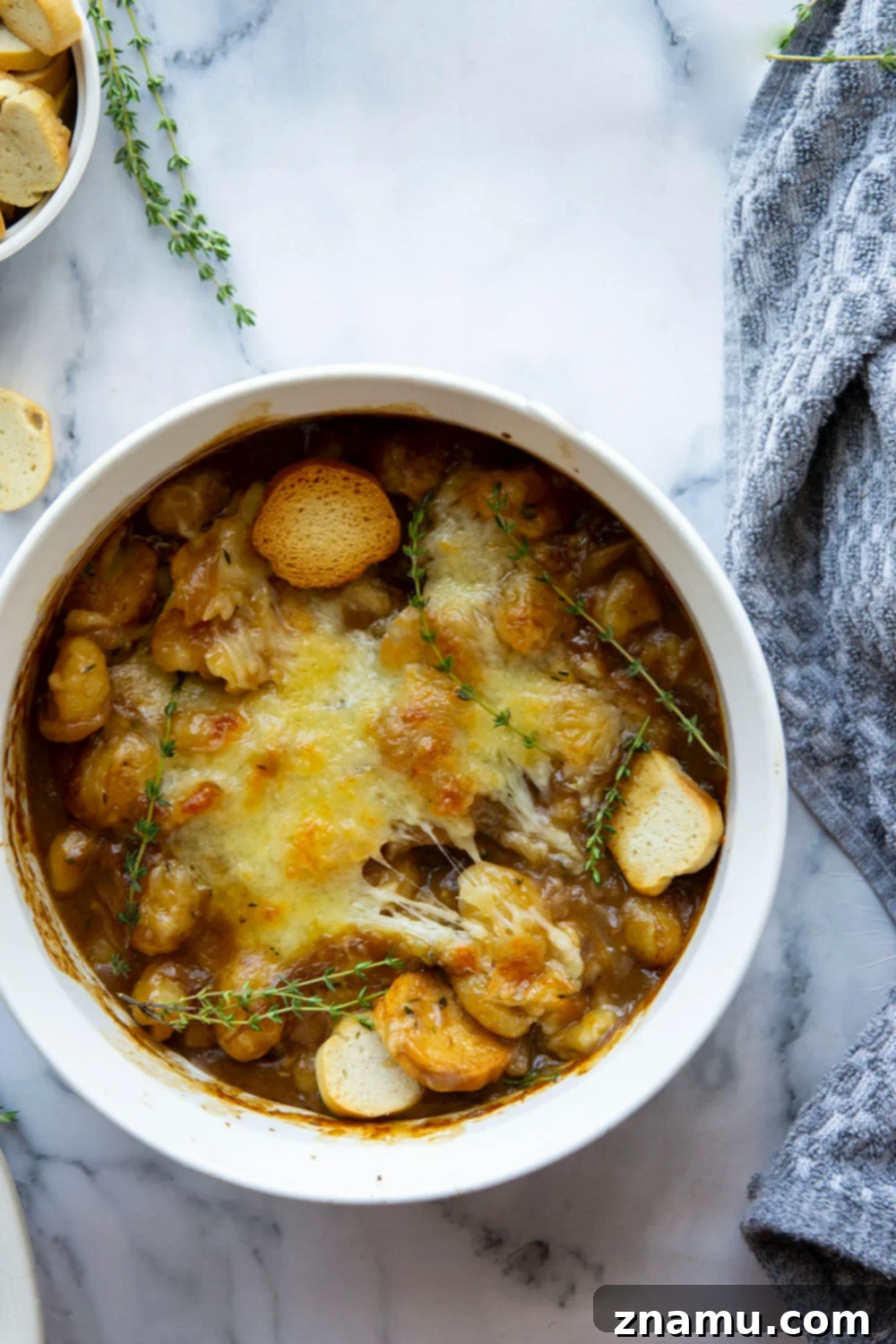 Savory Onion Gnocchi Gratin 4 This baked French onion gnocchi is like a heartier version of the classic soup! Tender gnocchi is baked in a flavorful caramelized onion beef broth with lots of rich cheese on top and French bread slices for dipping.