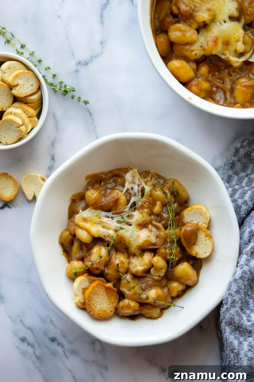 Savory Onion Gnocchi Gratin 5 This baked French onion gnocchi is like a heartier version of the classic soup! Tender gnocchi is baked in a flavorful caramelized onion beef broth with lots of rich cheese on top and French bread slices for dipping.
