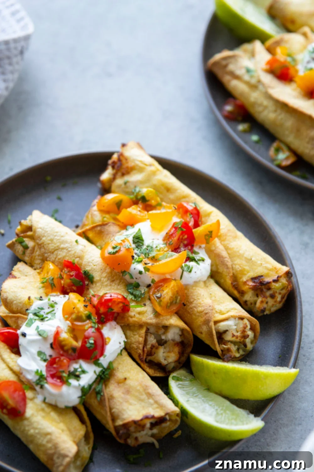 Crispy Air Fryer Green Chile Chicken Taquitos loaded with fresh toppings, perfect for game day