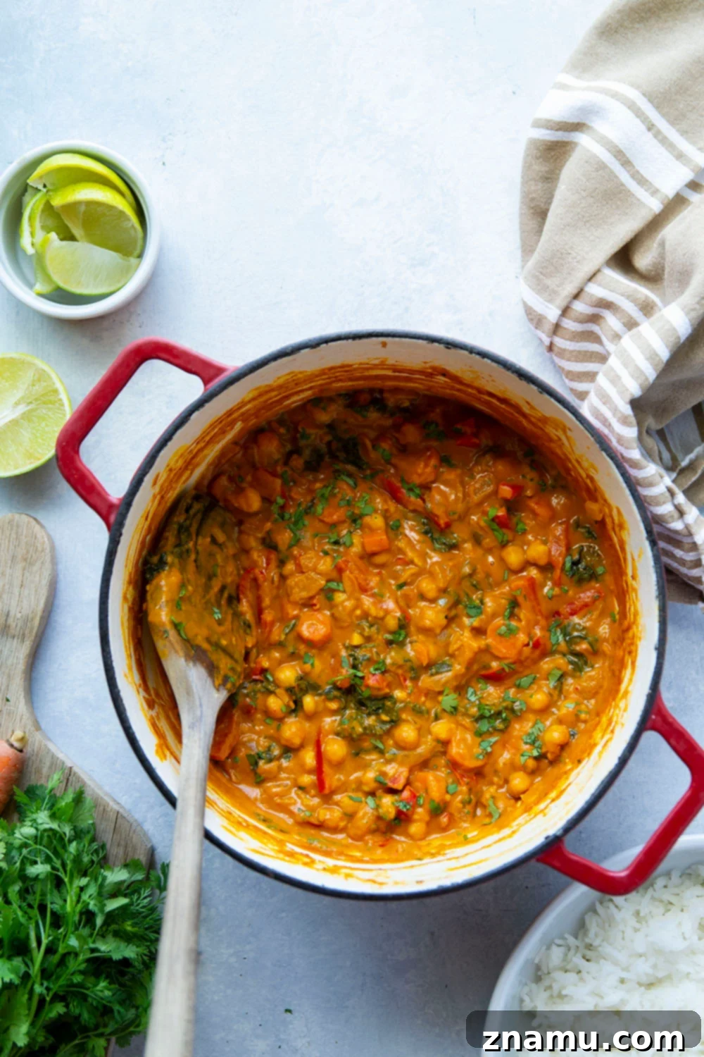 Golden Thai Pumpkin Curry 5 A serving of Thai pumpkin curry with fresh lime wedges and cilantro on top, ready to be enjoyed.