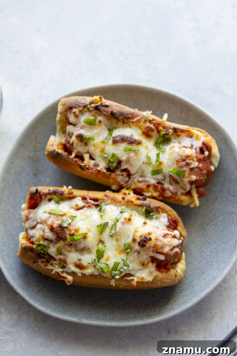 Cheesy Baked Meatball Subs 5 Homemade meatballs mixed with marinara sauce in a sheet pan, ready to be baked.