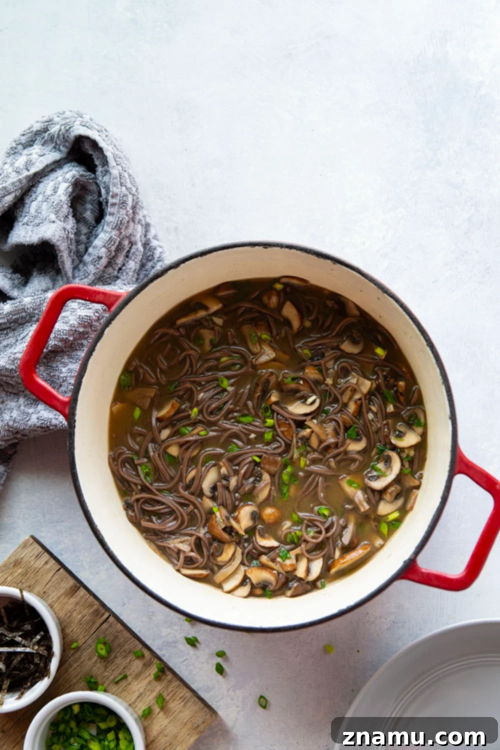 Soulful Miso Mushroom Noodles 2 A steaming bowl of Miso Mushroom Noodle Soup with sautéed mushrooms and soba noodles, garnished with fresh scallions.
