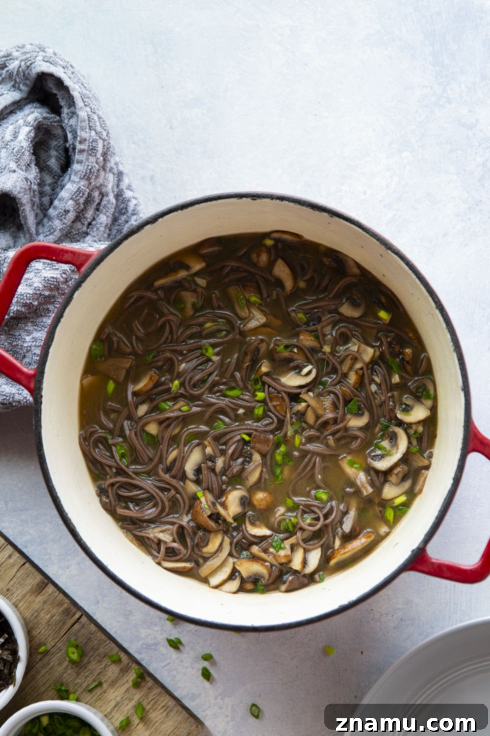 Soulful Miso Mushroom Noodles 6 A large serving spoon scooping Miso Mushroom Noodle Soup from a pot into a bowl.