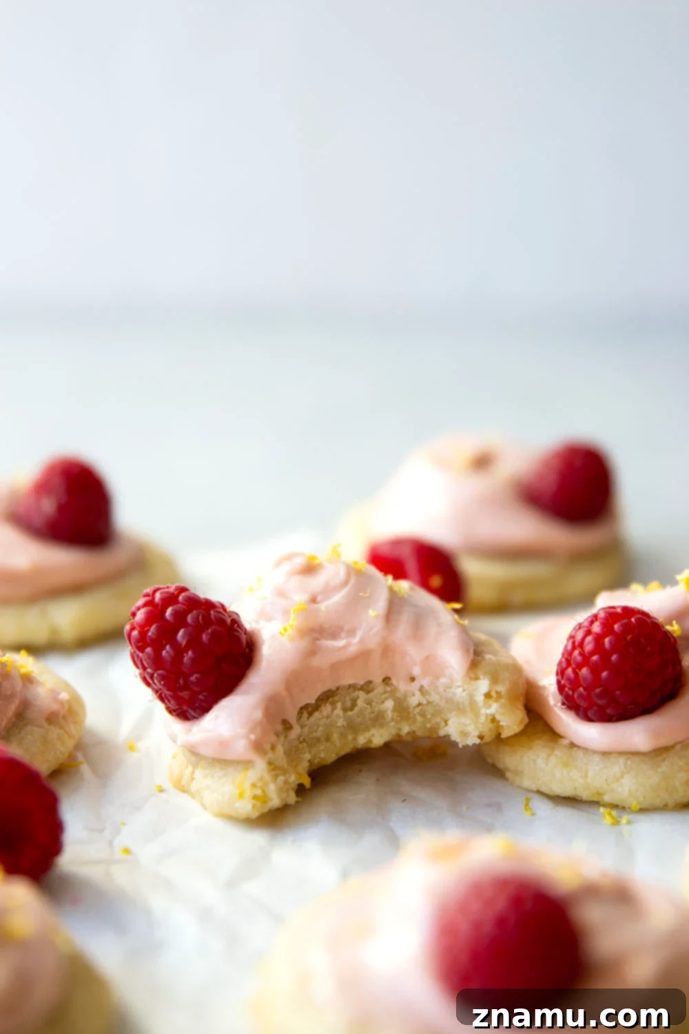 Soft and buttery lemon shortbread cookies frosted with a beautiful pink raspberry cream cheese frosting, perfect for spring