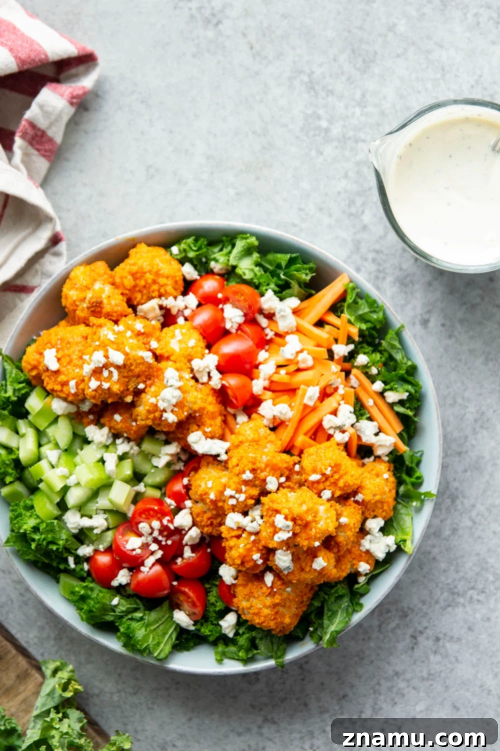 Fiery Buffalo Chicken Kale Delight 6 A vibrant Buffalo Chicken Kale Salad with crispy chicken, fresh greens, and creamy dressing in a large bowl, ready to be enjoyed.
