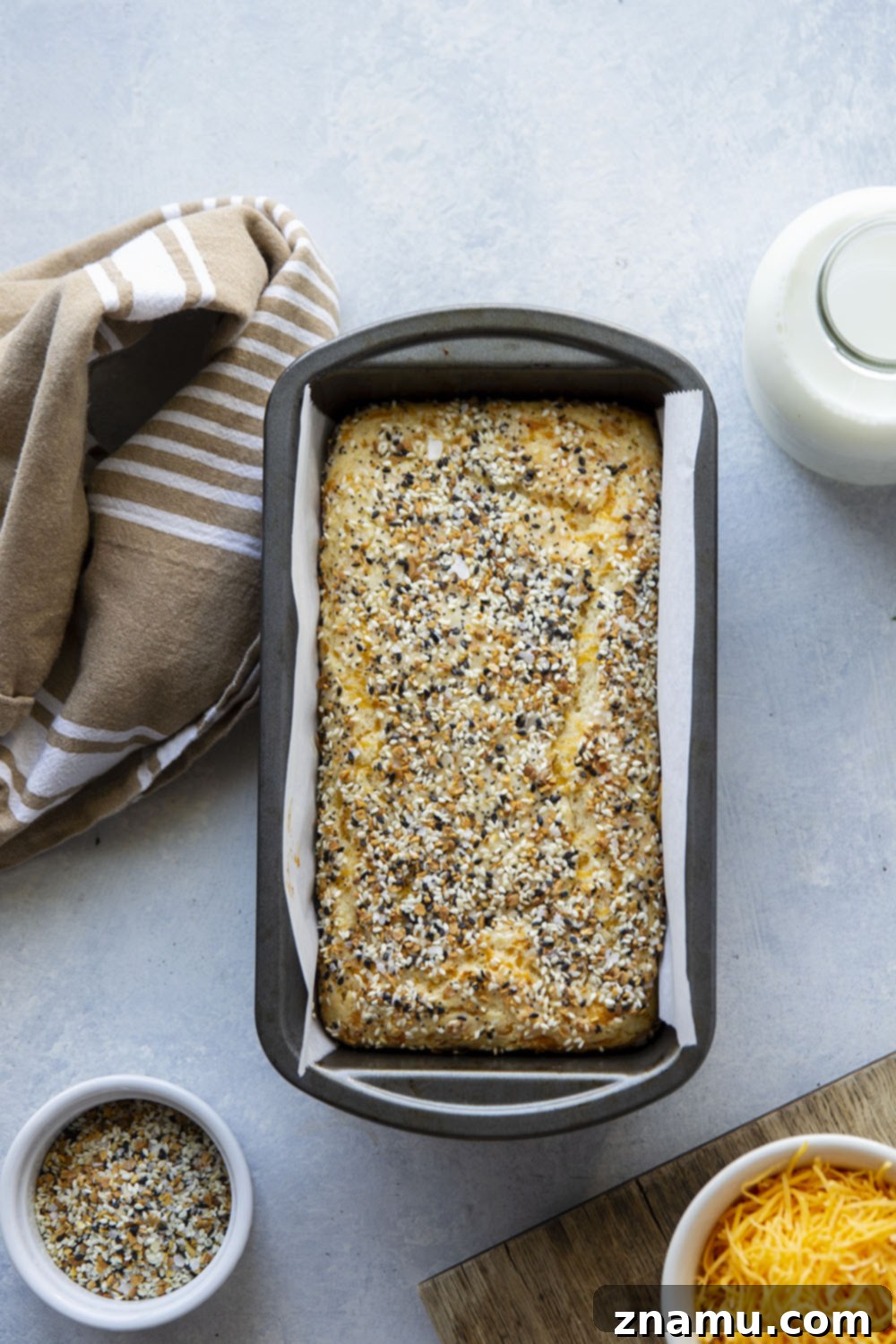 Everything Bagel Cheesy Loaf 3 Slice of Cheesy Everything Bagel Quick Bread revealing a soft, moist interior filled with melted cheddar and Parmesan cheese.