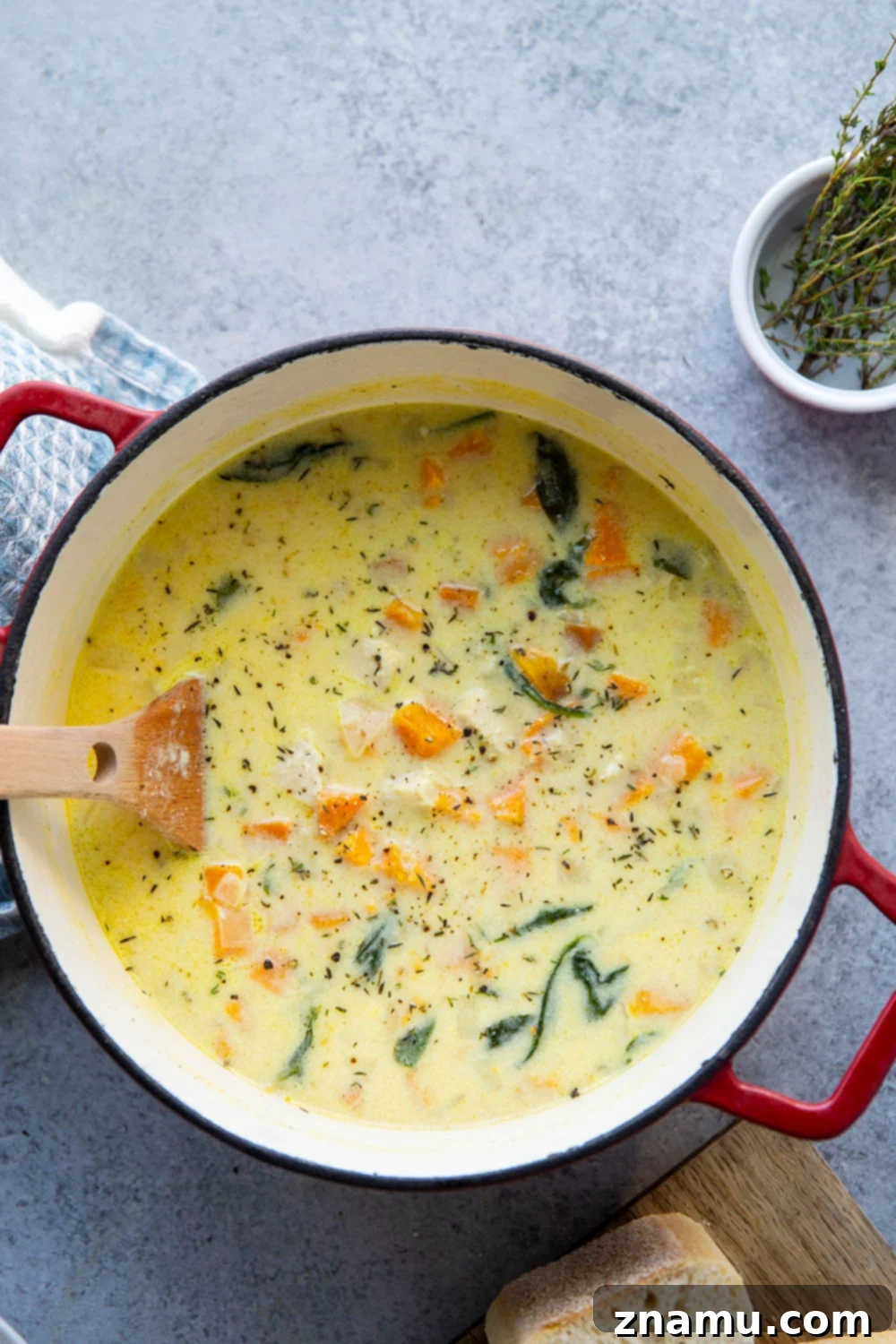 Golden Sweet Potato Chicken Bisque 3 Delicious chicken sweet potato soup in a bowl with a spoon, highlighting the creamy texture and fresh ingredients.