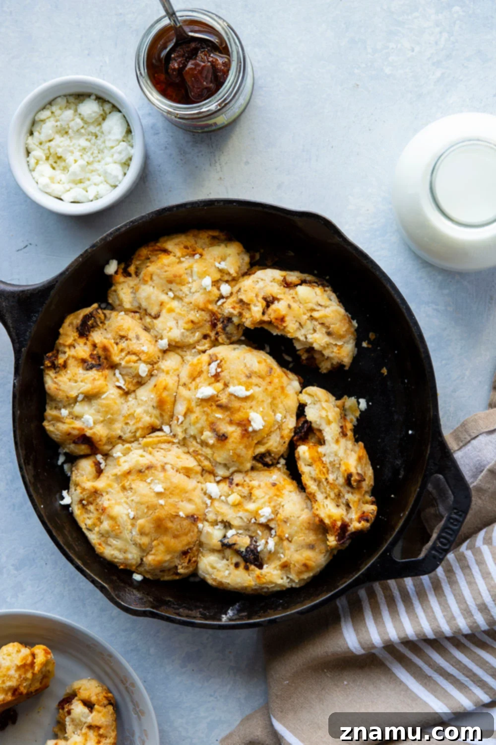 Sun-Kissed Feta Skillet Biscuits 2 Golden brown skillet biscuits with sun-dried tomatoes and feta cheese, ready to be served.