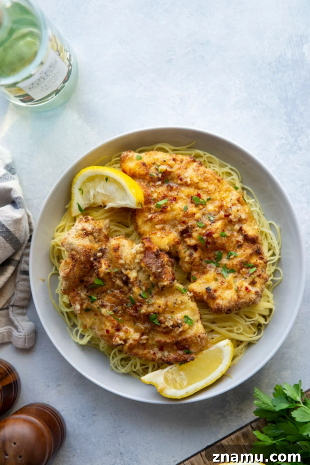 Crispy Air-Fried Chicken Milanese with a Luscious White Wine Sauce 2 This air fryer chicken milanese features perfectly crispy breaded chicken cutlets topped with a flavorful white wine sauce and piled over a bed of angel hair pasta.