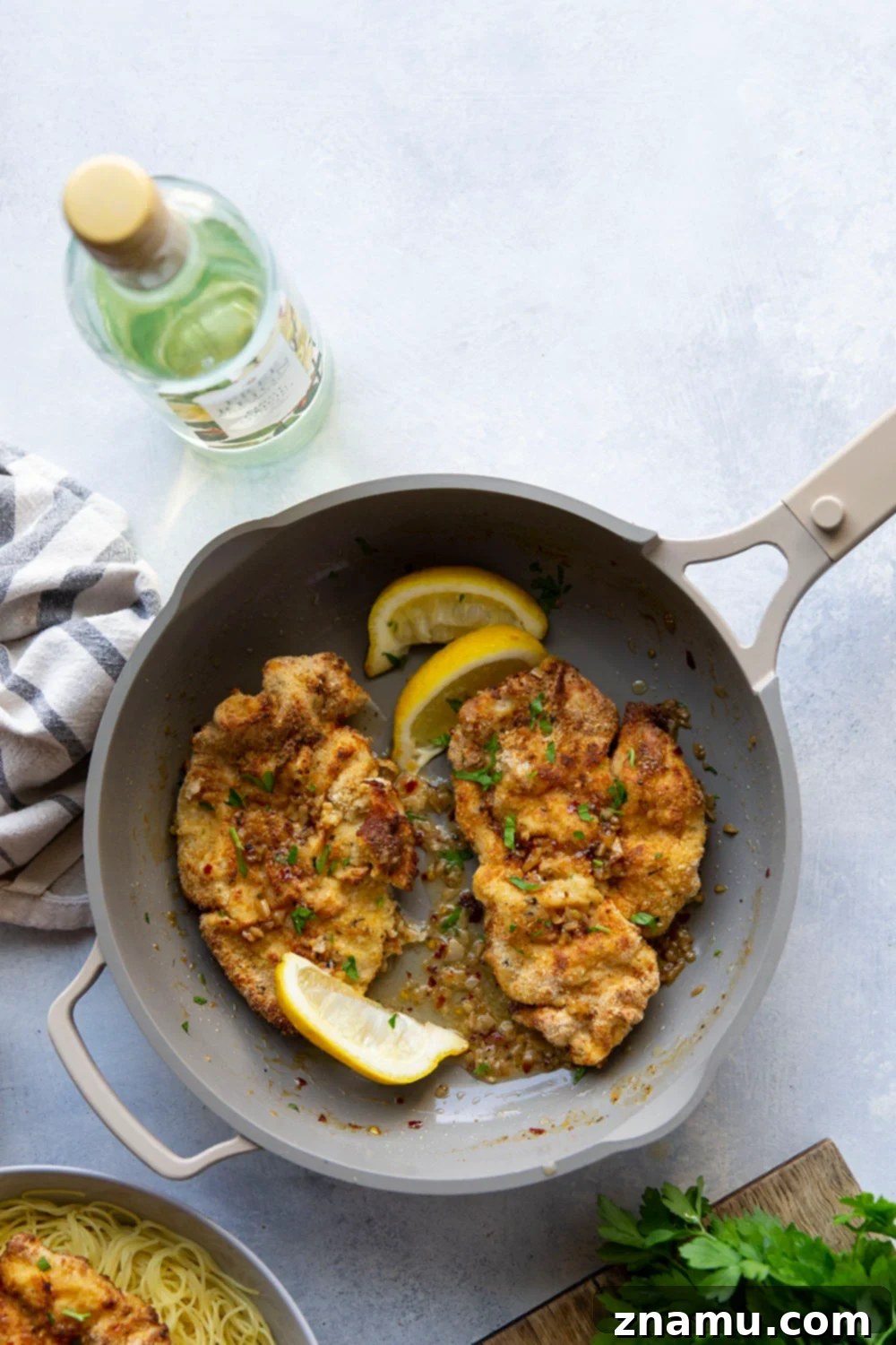 Crispy Air-Fried Chicken Milanese with a Luscious White Wine Sauce 3 This air fryer chicken milanese features perfectly crispy breaded chicken cutlets topped with a flavorful white wine sauce and piled over a bed of angel hair pasta.