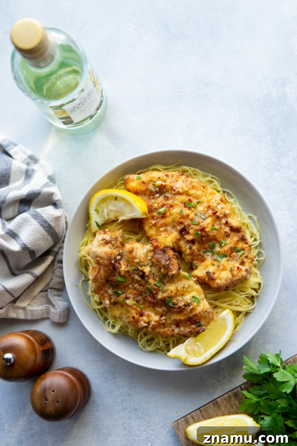 Crispy Air-Fried Chicken Milanese with a Luscious White Wine Sauce 4 This air fryer chicken milanese features perfectly crispy breaded chicken cutlets topped with a flavorful white wine sauce and piled over a bed of angel hair pasta.