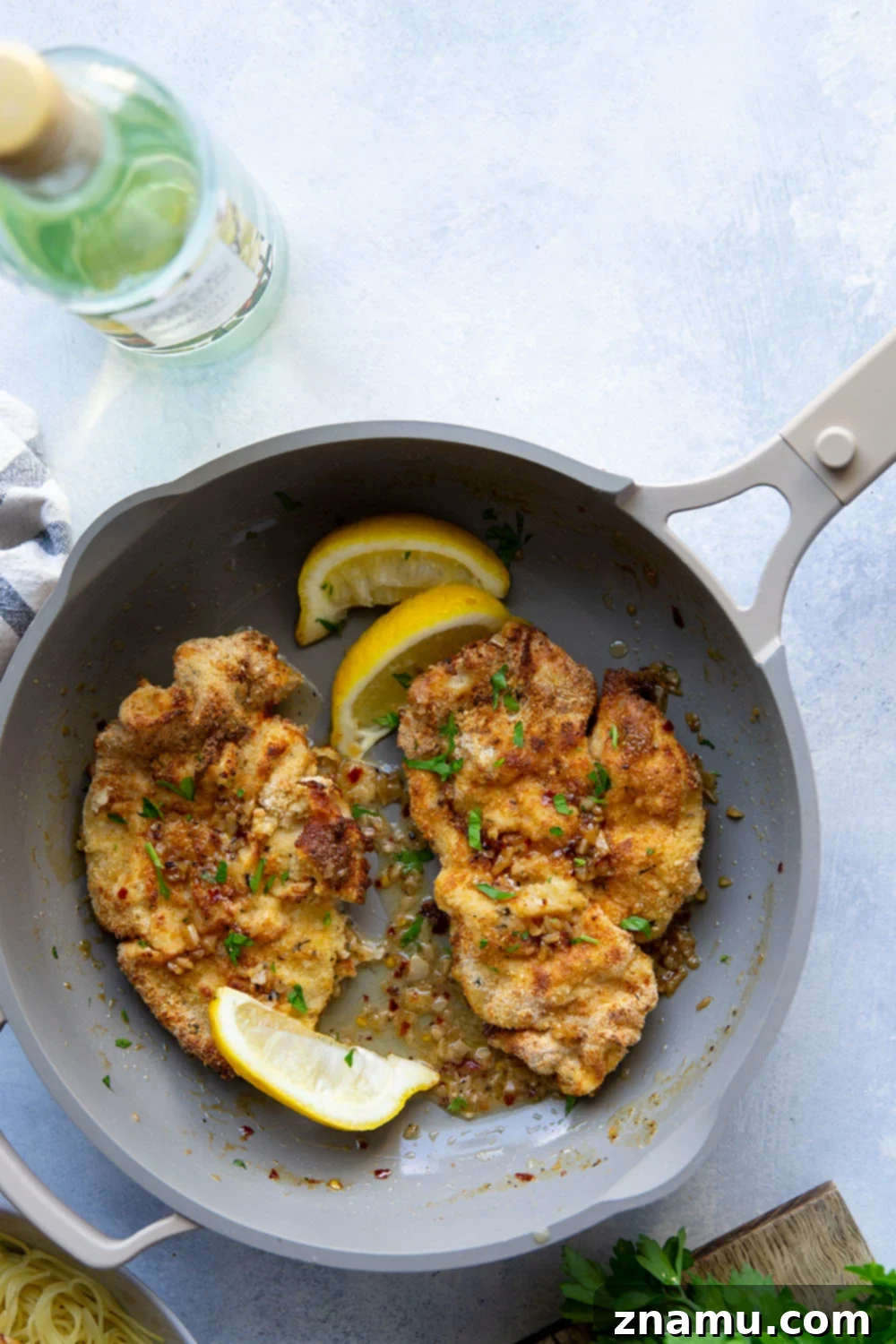 Crispy Air-Fried Chicken Milanese with a Luscious White Wine Sauce 5 This air fryer chicken milanese features perfectly crispy breaded chicken cutlets topped with a flavorful white wine sauce and piled over a bed of angel hair pasta.