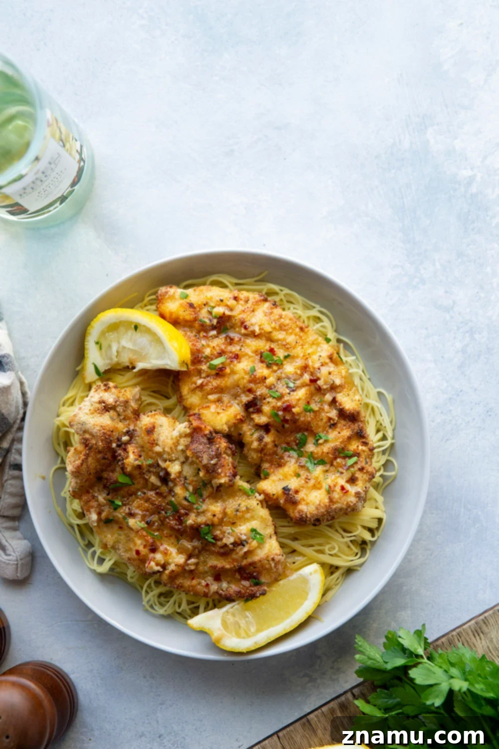 Crispy Air-Fried Chicken Milanese with a Luscious White Wine Sauce 6 This air fryer chicken milanese features perfectly crispy breaded chicken cutlets topped with a flavorful white wine sauce and piled over a bed of angel hair pasta.