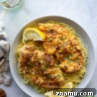 This air fryer chicken milanese features perfectly crispy breaded chicken cutlets topped with a flavorful white wine sauce and piled over a bed of angel hair pasta.
