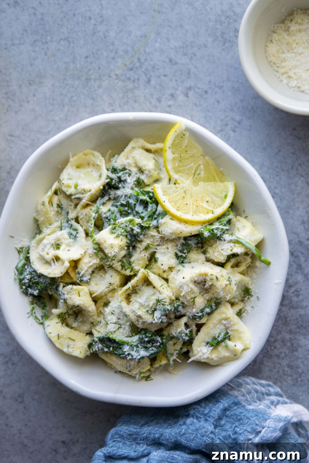 Zesty Lemon Dill Alfredo Tortellini 2 Creamy lemon dill alfredo tortellini with fresh spinach ready to serve in a bowl.