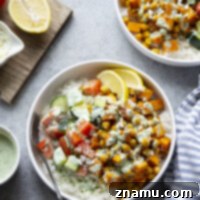 A vibrant and appetizing image of Sweet Potato Chickpea Shawarma Bowls, featuring roasted ingredients, fresh toppings, and a creamy sauce.