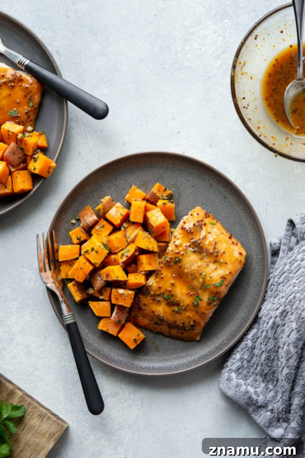 Honey Mustard Salmon with Garlic Butter Roasted Sweet Potatoes 3 Close-up of perfectly cooked honey mustard salmon fillets and roasted sweet potatoes on a sheet pan.