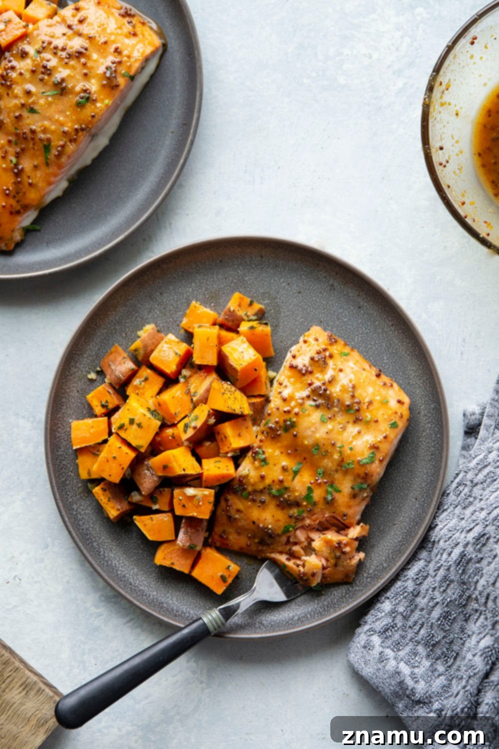 Honey Mustard Salmon with Garlic Butter Roasted Sweet Potatoes 6 A vibrant, close-up shot of cooked honey mustard salmon and garlic butter sweet potatoes, ready to be served.