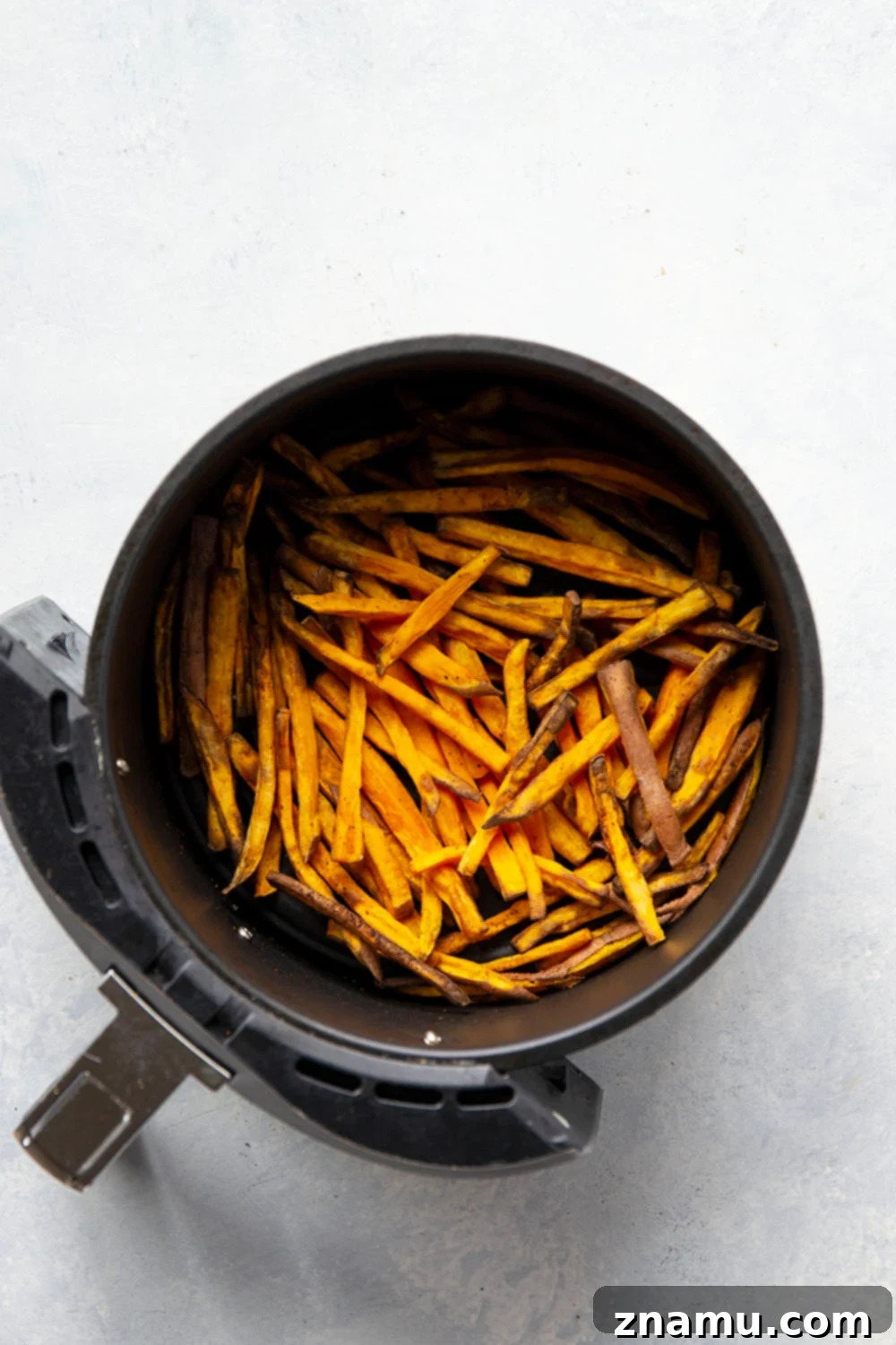 Crispy Air Fryer Sweet Potato Fries with Creamy Chipotle Aioli 3 Air Fryer Sweet Potato Fries cooking in the basket