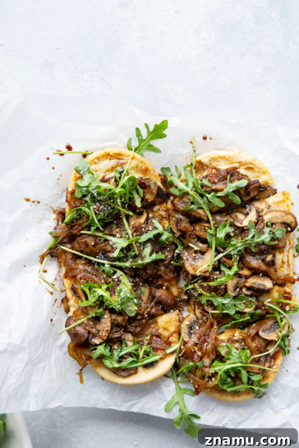 Close-up of a slice of Caramelized Onion Mushroom Flatbread showcasing the golden-brown crust, melted cheese, and tender mushroom and onion topping.