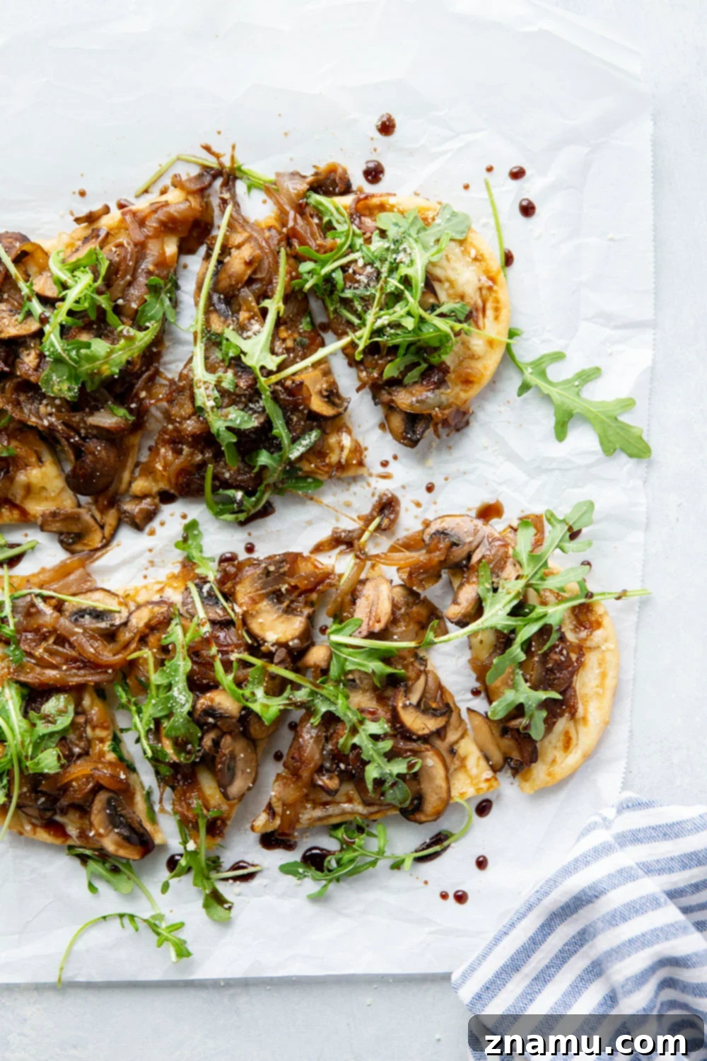 Close-up of a generous slice of Caramelized Onion Mushroom Flatbread on a wooden cutting board, ready to be enjoyed.