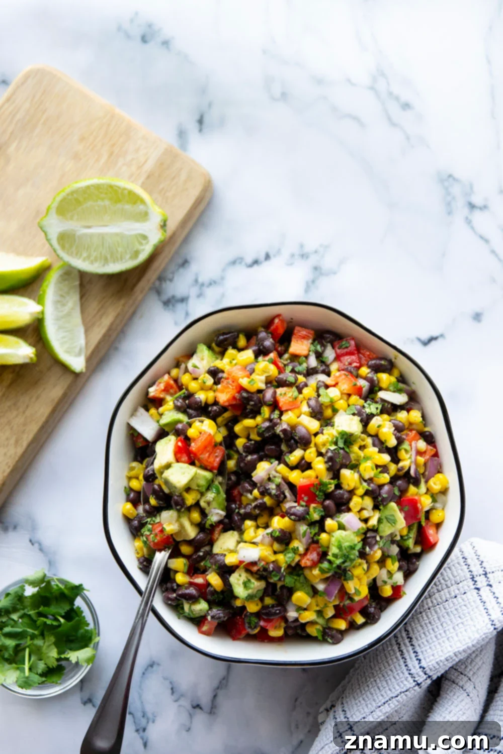 Vibrant Black Bean Corn Fiesta with Jalapeño Zing 5 A serving of Mexican Black Bean Corn Salad in a bowl, with a fork ready to enjoy.