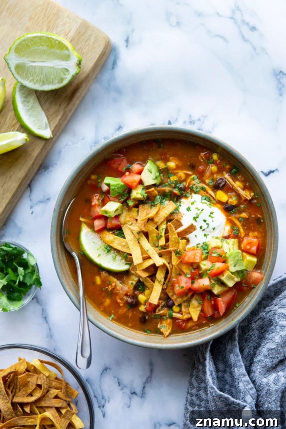 Easy Instant Pot Chicken Tortilla Soup 2 A vibrant bowl of Instant Pot Chicken Tortilla Soup, garnished with fresh cilantro, avocado, and crispy tortilla strips, ready to enjoy.