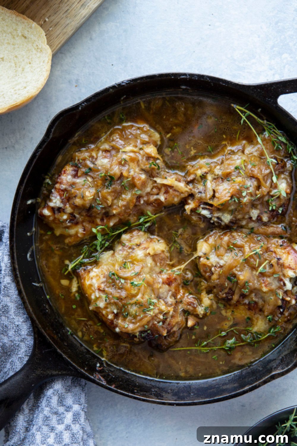 Close up of cheesy French onion chicken thighs with fresh thyme