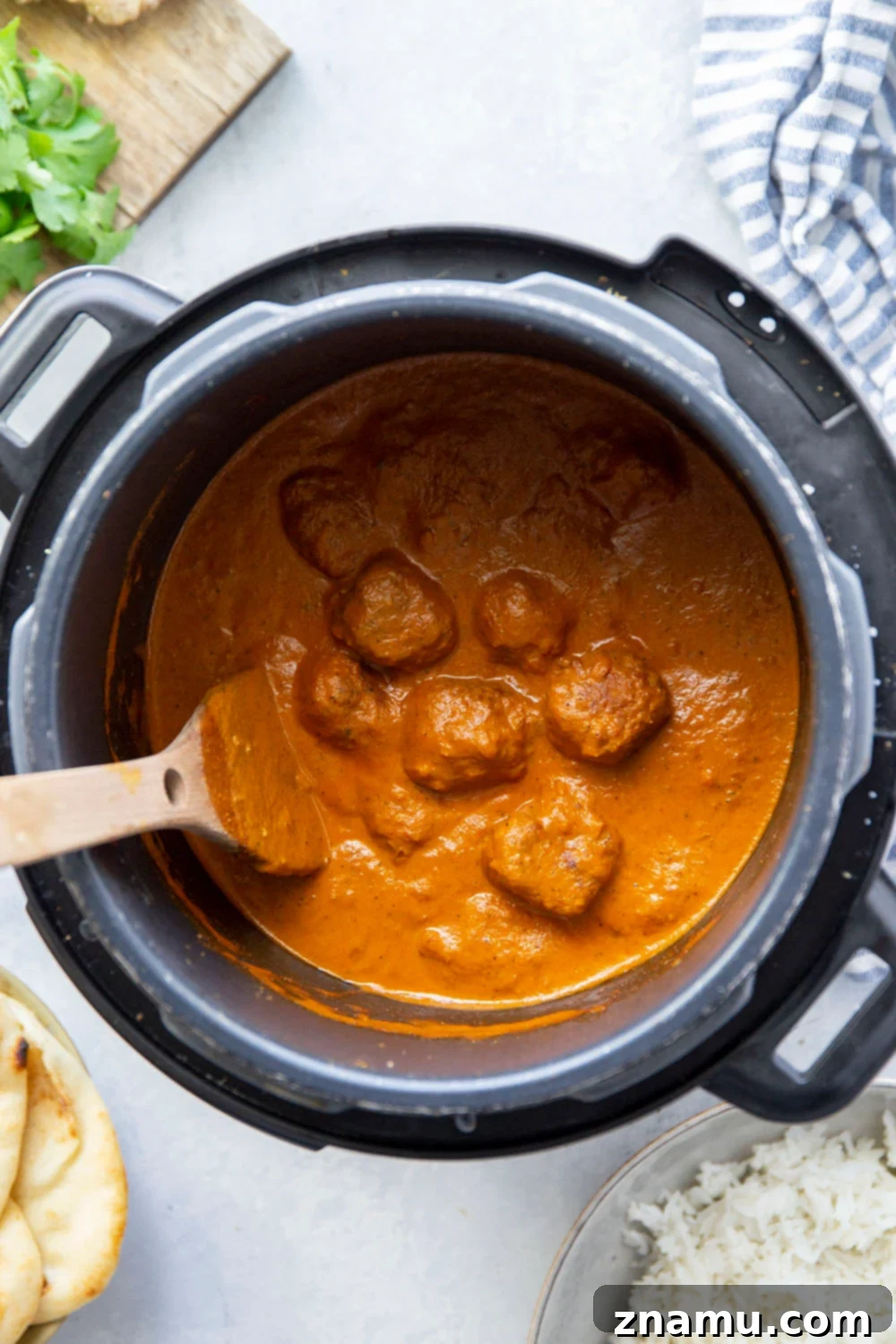 Creamy Instant Pot Butter Chicken Meatballs 3 Close-up of Instant Pot Butter Chicken Meatballs in a bowl with rice, cilantro, and naan, showcasing the rich sauce and perfectly cooked meatballs.