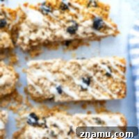 Buttery streusel, creamy glaze, and soft dried blueberries transform these soft and chewy blueberry muffin granola bars into a magical breakfast or snack. - all the best parts about a blueberry muffin!