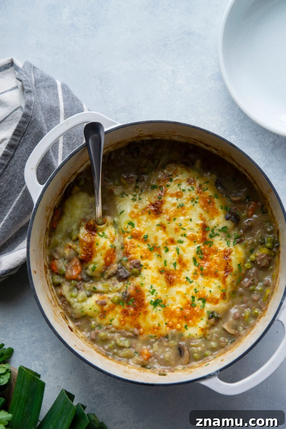 Rich White Cheddar Shepherds Pie with Leek and Mushroom Medley 2 Hearty Leek Mushroom Shepherd's Pie with golden mashed potato topping and melted white cheddar cheese, perfect for a comforting weeknight dinner.