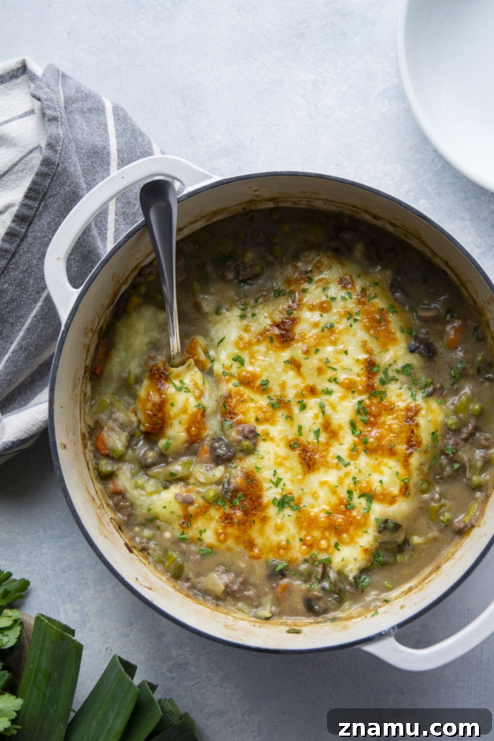 Rich White Cheddar Shepherds Pie with Leek and Mushroom Medley 6 A serving of Leek Mushroom Shepherd's Pie on a plate, garnished with fresh parsley.